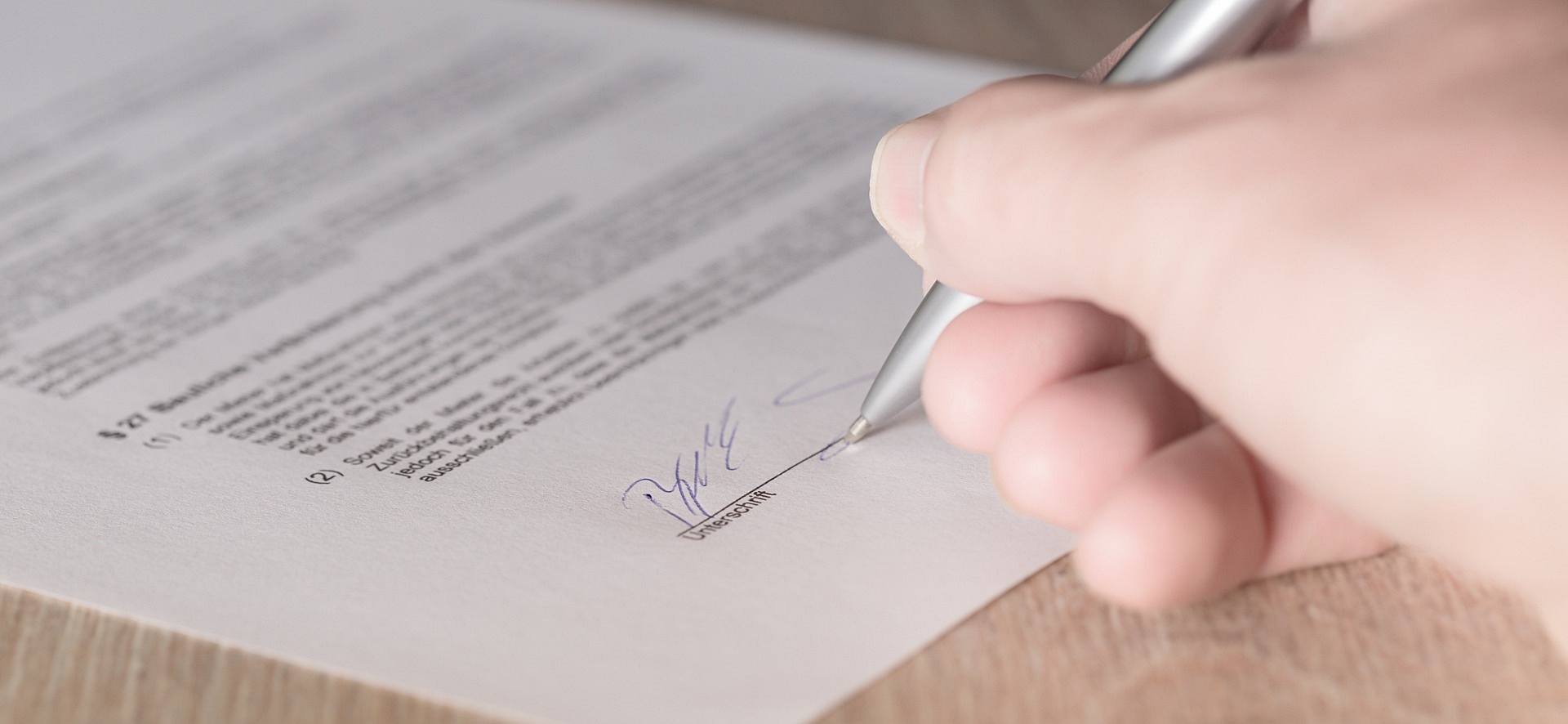Firma de un documento legal con papel y bolígrafo